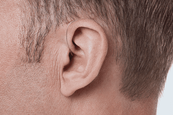 Apparecchio acustico Oticon More, modello miniRITE R, colore grigio chiaro, foto scattata con un angolo di 90°, primo piano dell'orecchio, apparecchio acustico maschile Auzen con servizio illimitato