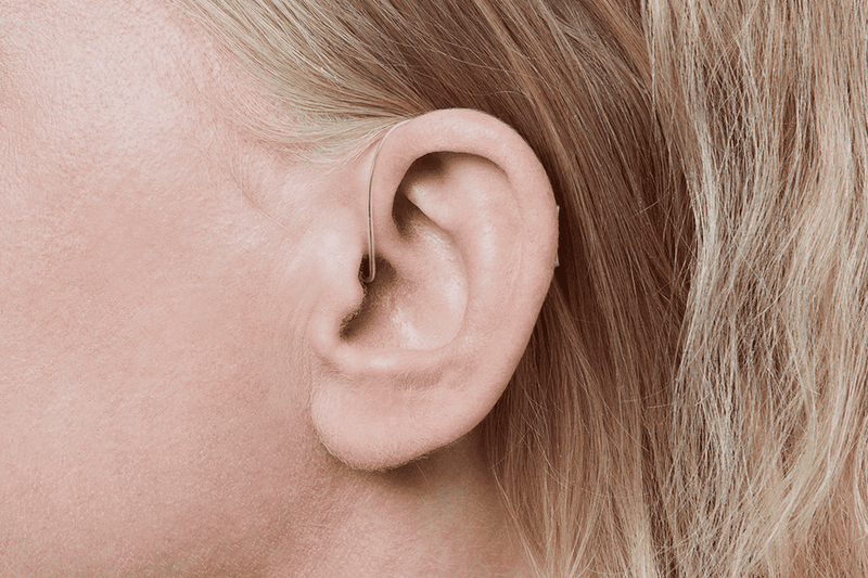 Apparecchio acustico Oticon More, modello miniRITE R, colore grigio chiaro, foto scattata da un'angolazione di 90°, primo piano dell'orecchio, femmina Apparecchio acustico Auzen Unlimited Service